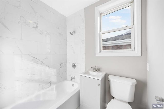 full bathroom with vanity, tiled shower / bath combo, and toilet