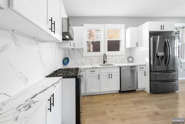 kitchen featuring appliances with stainless steel finishes, white cabinetry, and plenty of natural light