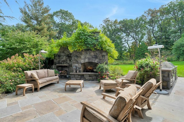 view of patio with an outdoor living space with a fireplace