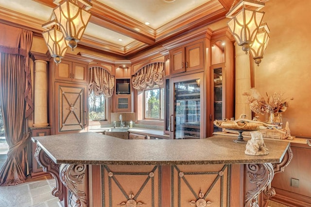 kitchen with pendant lighting, coffered ceiling, ornamental molding, and sink