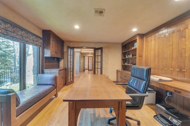 home office with light hardwood / wood-style flooring and french doors