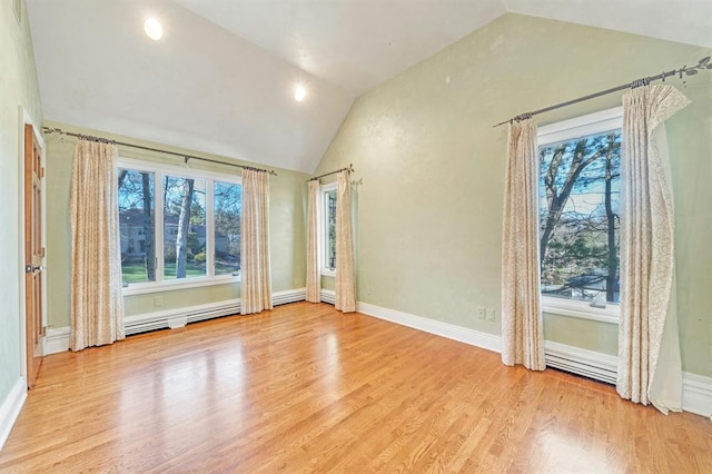 unfurnished room with a healthy amount of sunlight, vaulted ceiling, and light wood-type flooring