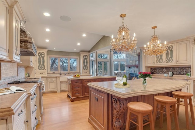 kitchen with a breakfast bar area, backsplash, cream cabinets, and a kitchen island