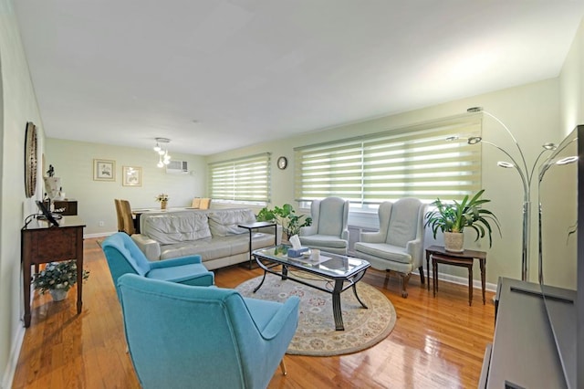 living room with hardwood / wood-style floors and an AC wall unit