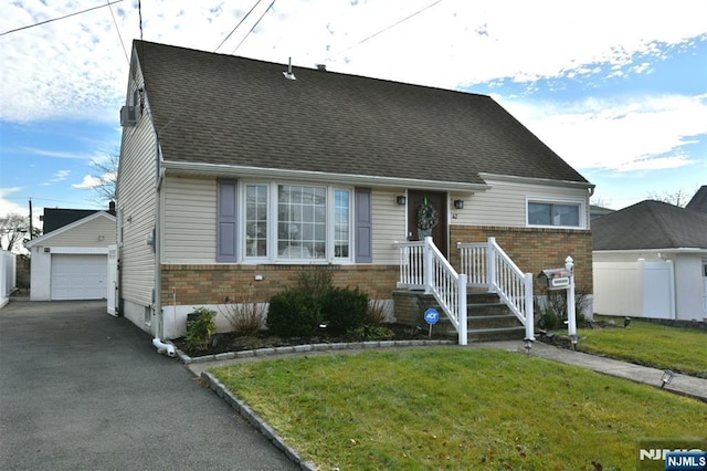 view of front of house with an outbuilding, a front yard, and a garage