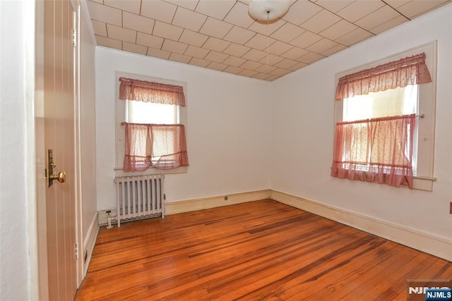 spare room with light hardwood / wood-style flooring and radiator heating unit