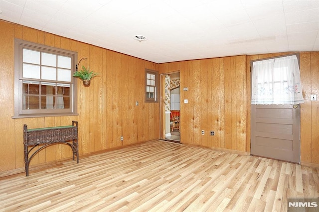 foyer entrance featuring wooden walls and light wood-type flooring