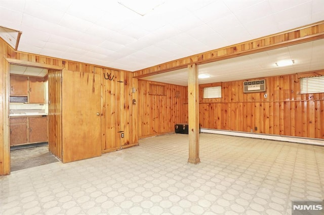 basement with a baseboard radiator, a wall mounted air conditioner, and wood walls