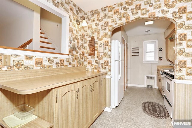 kitchen with white appliances, sink, and light brown cabinets