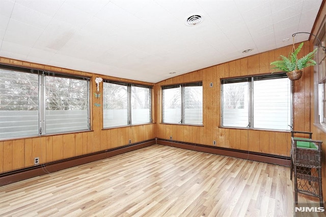 unfurnished sunroom with baseboard heating, vaulted ceiling, and a wealth of natural light