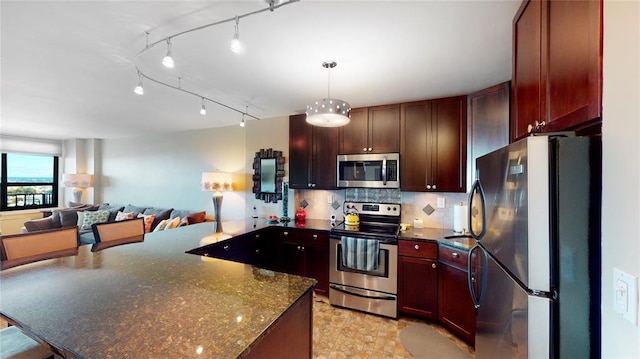 kitchen featuring rail lighting, tasteful backsplash, dark stone counters, stainless steel appliances, and pendant lighting