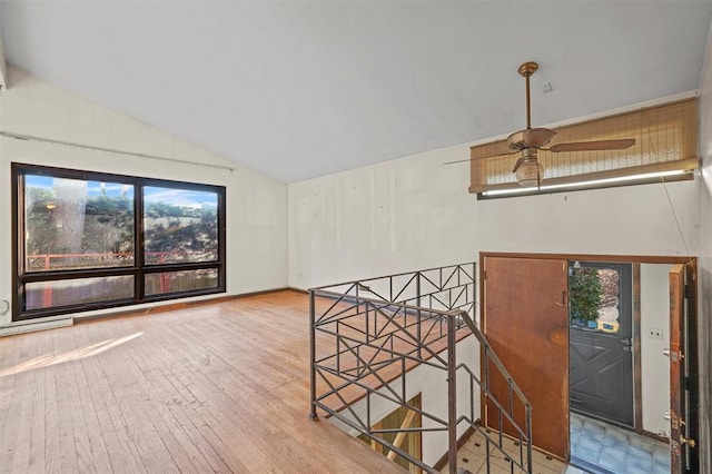 interior space featuring ceiling fan, wood-type flooring, and vaulted ceiling