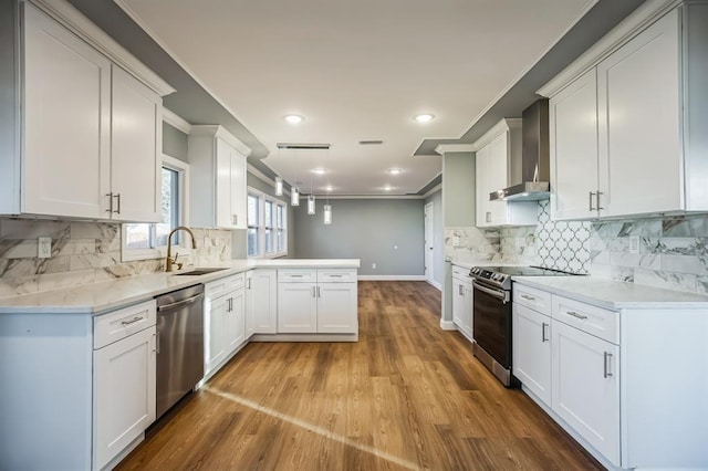 kitchen with white cabinets, sink, wall chimney exhaust hood, tasteful backsplash, and stainless steel appliances