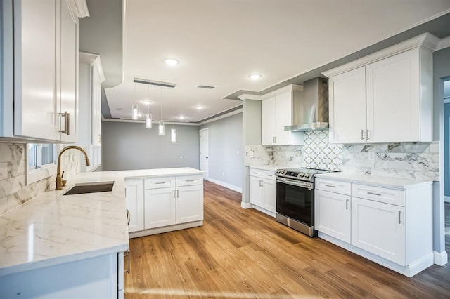 kitchen featuring white cabinetry, wall chimney exhaust hood, hanging light fixtures, crown molding, and stainless steel range with electric cooktop