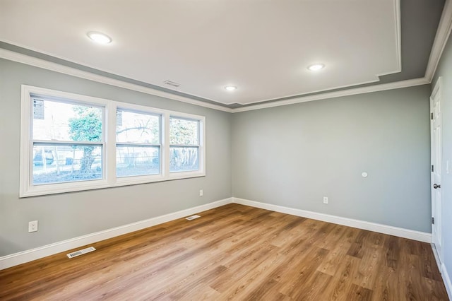 empty room with light hardwood / wood-style flooring and crown molding