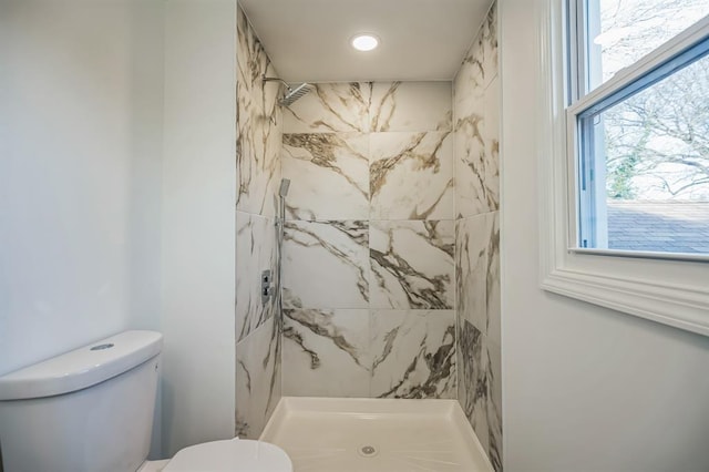 bathroom featuring toilet and a tile shower