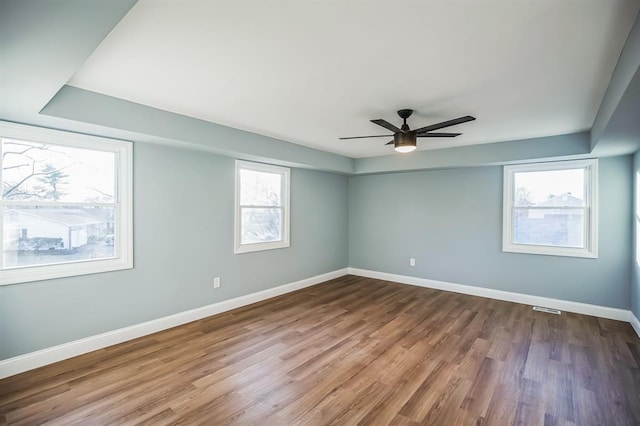 spare room featuring hardwood / wood-style flooring, a wealth of natural light, and ceiling fan