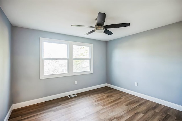 empty room with hardwood / wood-style floors and ceiling fan