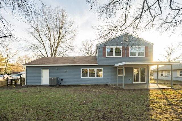 rear view of house with a lawn, central air condition unit, and a patio