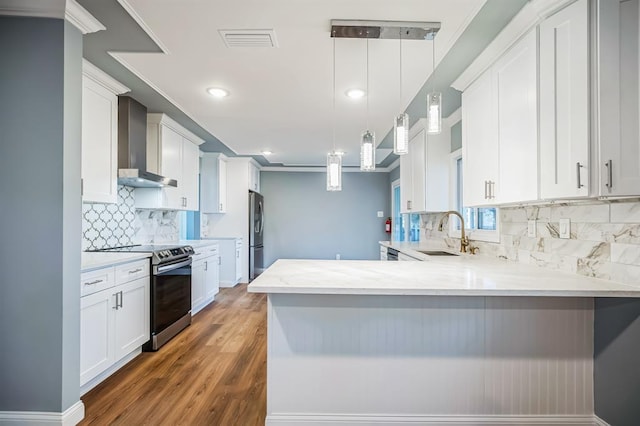 kitchen with white cabinetry, sink, wall chimney exhaust hood, pendant lighting, and appliances with stainless steel finishes