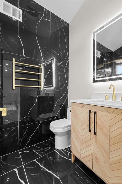 bathroom featuring walk in shower, decorative backsplash, vanity, and toilet