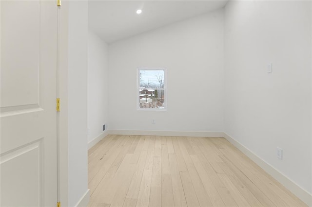 empty room featuring light hardwood / wood-style flooring and vaulted ceiling