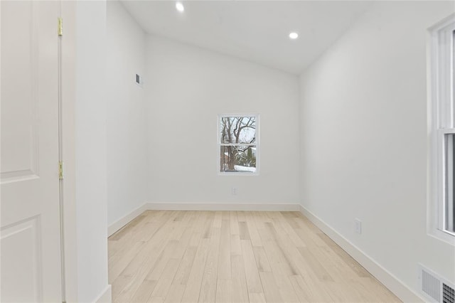 spare room featuring light hardwood / wood-style flooring and vaulted ceiling