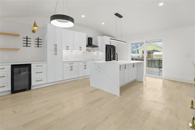 kitchen featuring light hardwood / wood-style floors, white cabinetry, beverage cooler, and vaulted ceiling