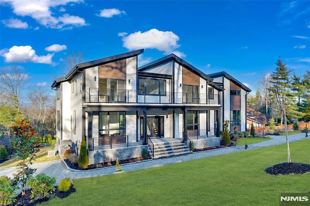 view of front of property with a balcony, a front lawn, and a porch