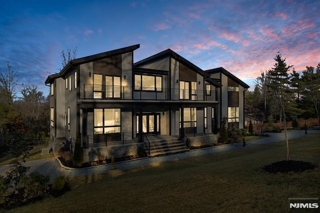 view of front of property with a lawn, a porch, and a balcony