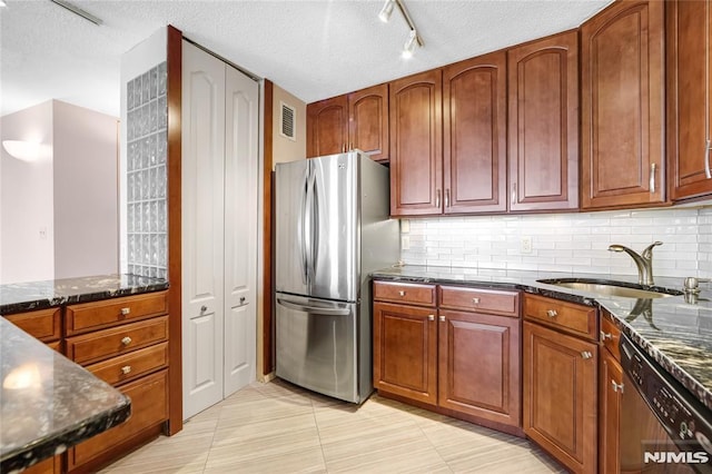 kitchen featuring light tile patterned flooring, dark stone countertops, sink, and appliances with stainless steel finishes