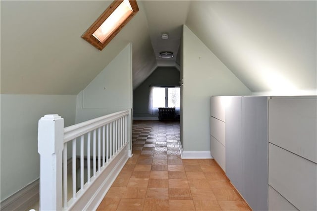 additional living space with vaulted ceiling with skylight