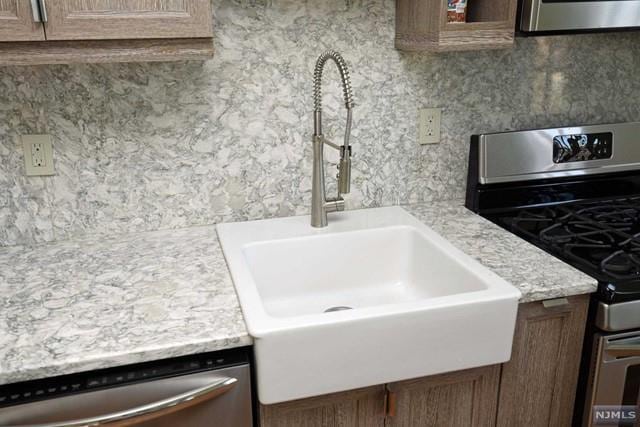 interior details featuring sink and appliances with stainless steel finishes