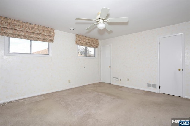 unfurnished room featuring light colored carpet and ceiling fan