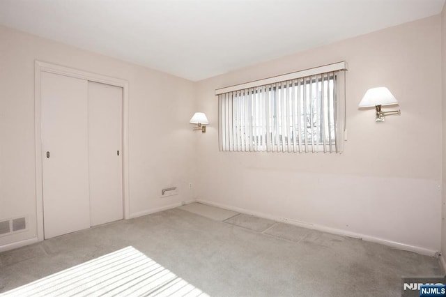 unfurnished bedroom with a closet and light carpet