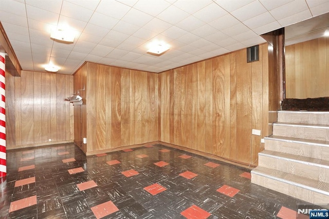 basement featuring wood walls