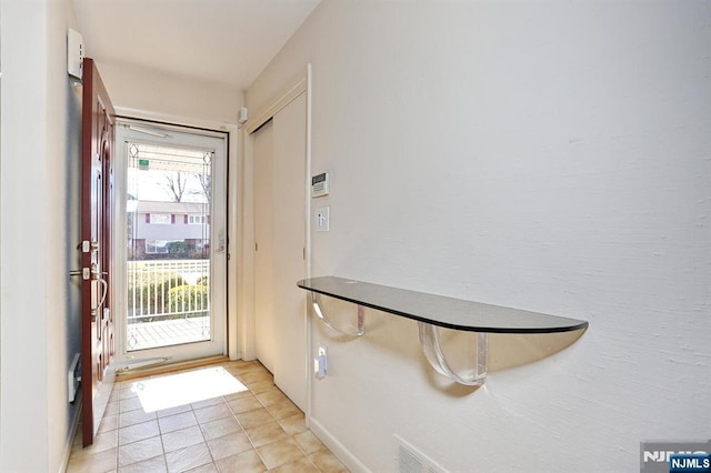 doorway with light tile patterned floors