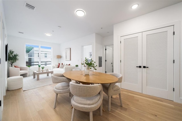 dining space featuring electric panel and light hardwood / wood-style flooring