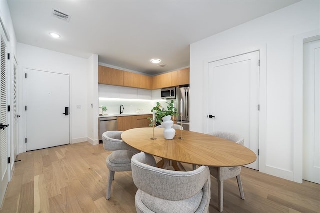 dining room featuring light hardwood / wood-style flooring and sink