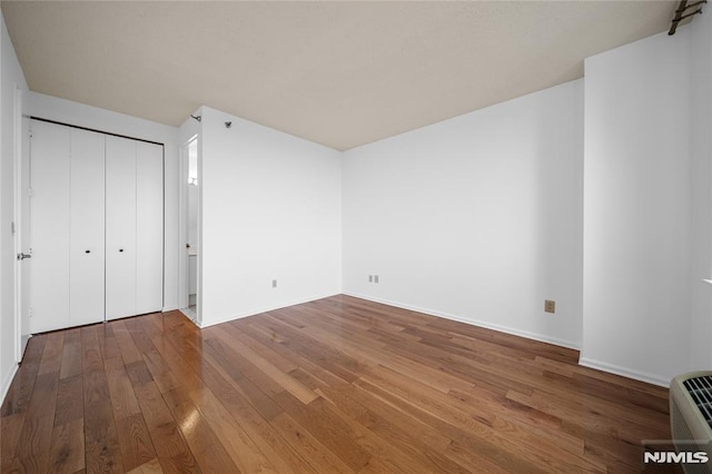 unfurnished bedroom featuring a closet and wood-type flooring