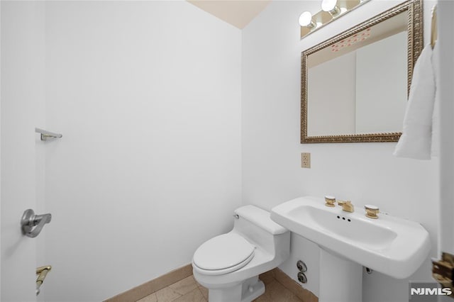 bathroom featuring tile patterned flooring, toilet, and sink