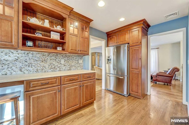 kitchen with stainless steel fridge, light hardwood / wood-style flooring, tasteful backsplash, and a baseboard heating unit