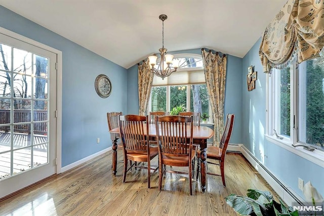 dining space featuring lofted ceiling, a baseboard heating unit, an inviting chandelier, and hardwood / wood-style floors