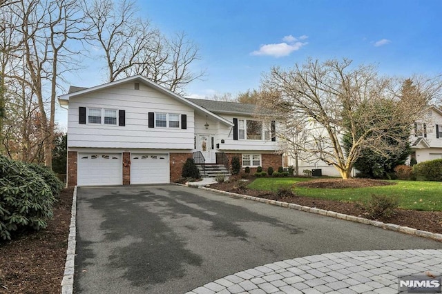 split foyer home featuring a front yard and a garage