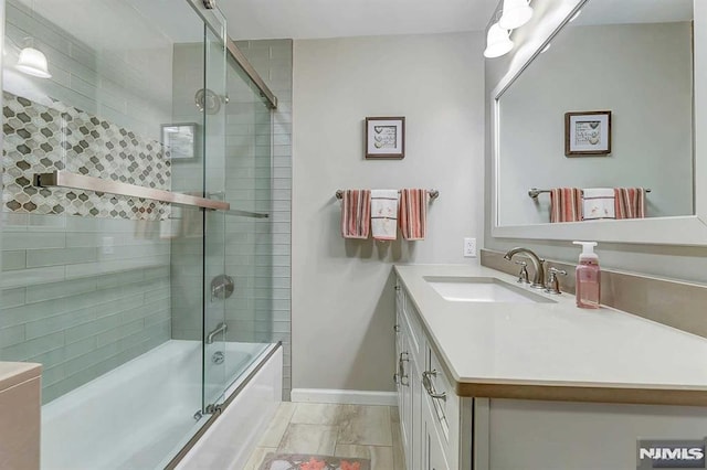 bathroom featuring tile patterned flooring, shower / bath combination with glass door, and vanity