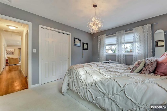 carpeted bedroom featuring a closet and an inviting chandelier