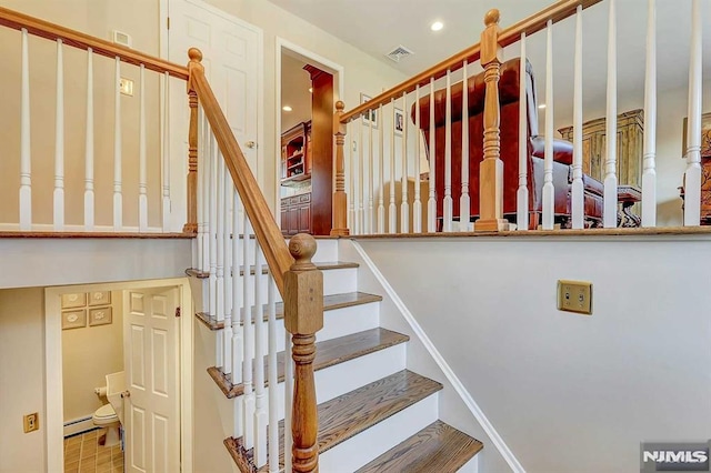 staircase featuring baseboard heating