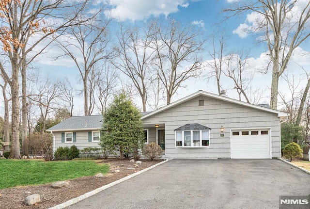 single story home with a front yard and a garage