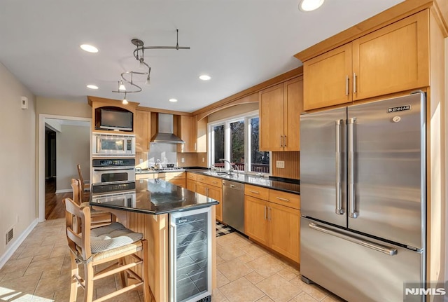 kitchen featuring a center island, stainless steel appliances, wall chimney range hood, wine cooler, and sink