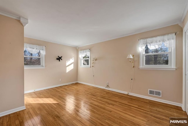 empty room with hardwood / wood-style floors and plenty of natural light